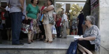 Pensioners wait outside Greece's largest Social Security Organisation (IKA) in Athens, Friday, May 31, 2013. Hundreds of retirees waited in line for hours outside IKA offices Friday, after missing a deadline to renew their pension registration as part of an effort in the bailed out country to combat benefit fraud. (AP Photo/Petros Giannakouris)