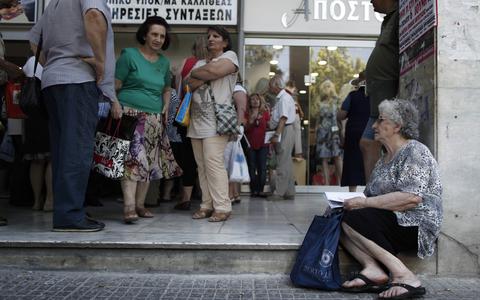 Pensioners wait outside Greece's largest Social Security Organisation (IKA) in Athens, Friday, May 31, 2013. Hundreds of retirees waited in line for hours outside IKA offices Friday, after missing a deadline to renew their pension registration as part of an effort in the bailed out country to combat benefit fraud. (AP Photo/Petros Giannakouris)