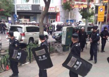 (140522) -- URUMQI, May 22, 2014 (Xinhua) -- Police officers stand guard near a blast scene, which has been cordoned off, in downtown Urumqi, capital of northwest China's Xinjiang Uygur Autonomous Region, May 22, 2014. An unknown number of people were killed and injured after explosions occurred Thursday morning at an open market in Urumqi. Witnesses said two cross-country vehicles driving from north to south ploughed into people in the market at 7:50 a.m. Explosives were thrown out of the vehicles. One of the vehicles exploded in the market. All injured people have been sent to hospital while investigations are underway. (Xinhua/Cao Zhiheng) (lmm)