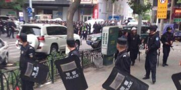 (140522) -- URUMQI, May 22, 2014 (Xinhua) -- Police officers stand guard near a blast scene, which has been cordoned off, in downtown Urumqi, capital of northwest China's Xinjiang Uygur Autonomous Region, May 22, 2014. An unknown number of people were killed and injured after explosions occurred Thursday morning at an open market in Urumqi. Witnesses said two cross-country vehicles driving from north to south ploughed into people in the market at 7:50 a.m. Explosives were thrown out of the vehicles. One of the vehicles exploded in the market. All injured people have been sent to hospital while investigations are underway. (Xinhua/Cao Zhiheng) (lmm)