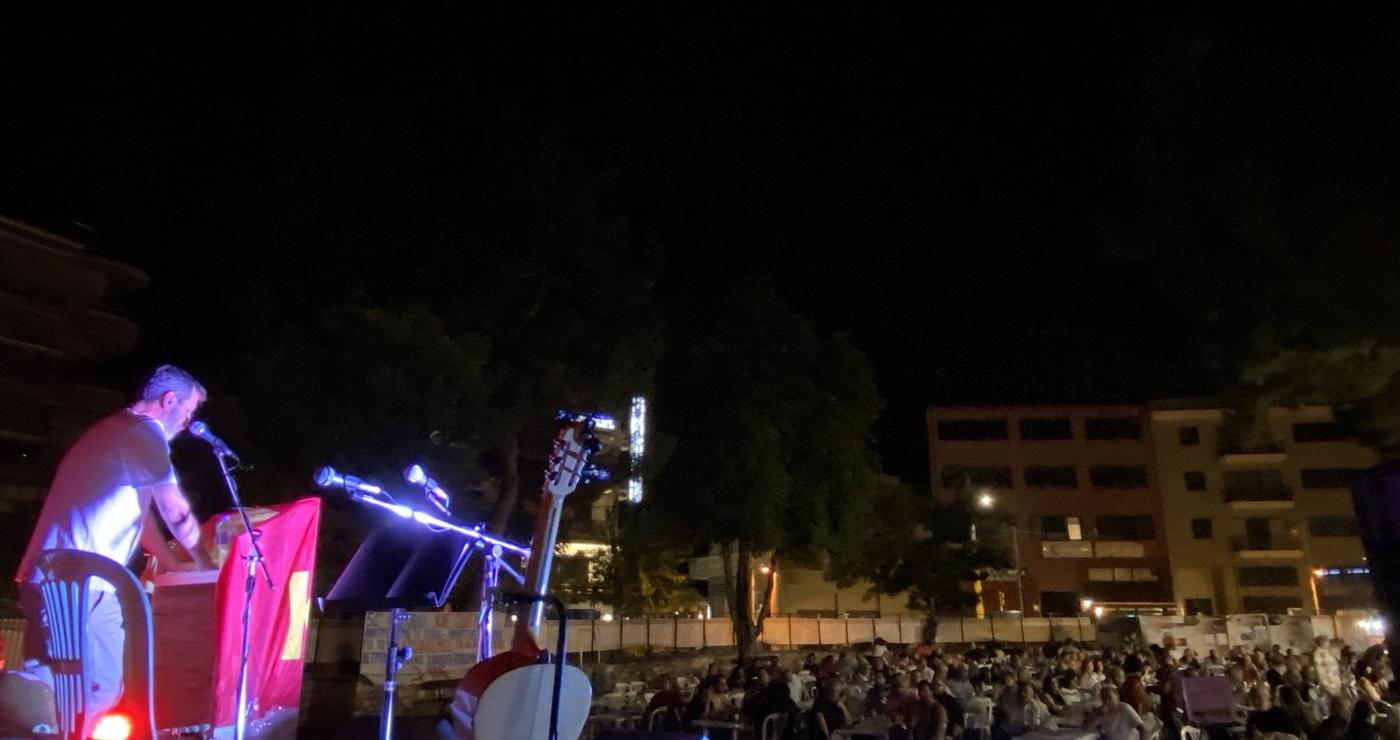 Μια σκηνή από το Φεστιβάλ ΚΝΕ – Οδηγητή, με έναν ομιλητή στο βήμα και πλήθος κόσμου να παρακολουθεί σε μια νυχτερινή πλατεία.