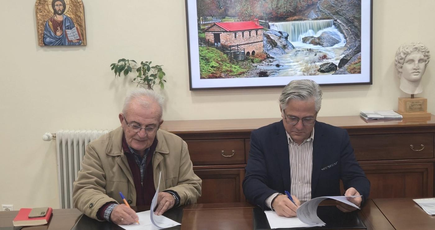 Δύο άνδρες, ο δήμαρχος Βοΐου και ο ανάδοχος, υπογράφουν τη σύμβαση για την ανάδειξη του κτιρίου του συνεταιρισμού στην Εράτυρα.