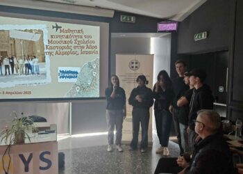 A group of people stand in a room during the Erasmus Days 2025 event, with a projected image of a historical scene and the Erasmus+ logo visible on a screen.