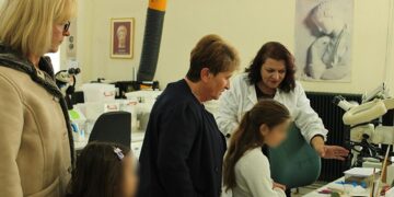 Μια συντηρήτρια αρχαιοτήτων εξηγεί τη διαδικασία συντήρησης σε μια ομάδα επισκεπτών, συμπεριλαμβανομένων παιδιών, στο εργαστήριο του Αρχαιολογικού Μουσείου Αιανής, στο πλαίσιο της δράσης Συντήρηση Αρχαιοτήτων Κοζάνη.