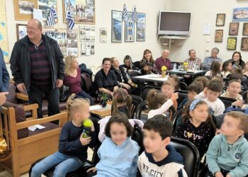 Μαθητές Αμυνταίου συνομιλούν με μέλη του Κ.Α.Π.Η. κατά τη διάρκεια της εκδήλωσης για το “ΟΧΙ”, γεμίζοντας την αίθουσα με χαμόγελα και ιστορίες.