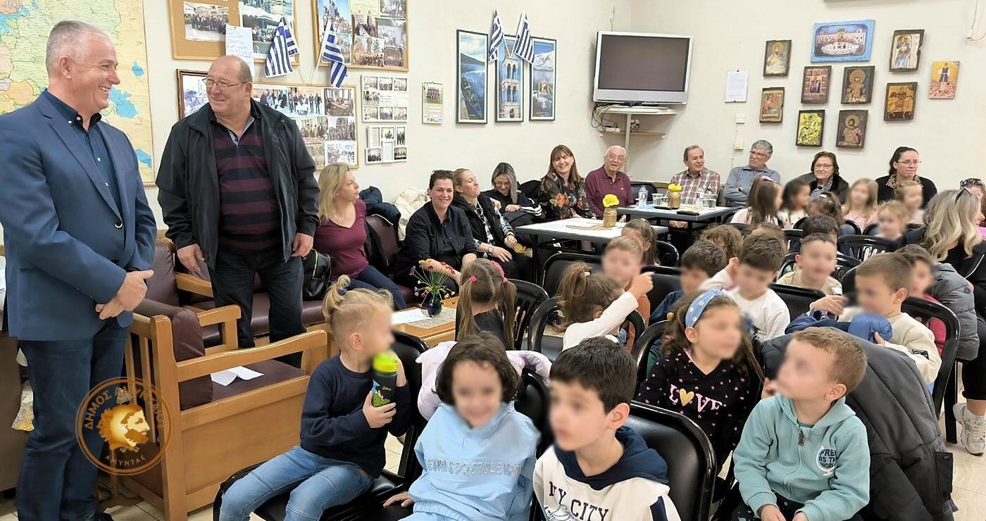 Μαθητές Αμυνταίου συνομιλούν με μέλη του Κ.Α.Π.Η. κατά τη διάρκεια της εκδήλωσης για το “ΟΧΙ”, γεμίζοντας την αίθουσα με χαμόγελα και ιστορίες.