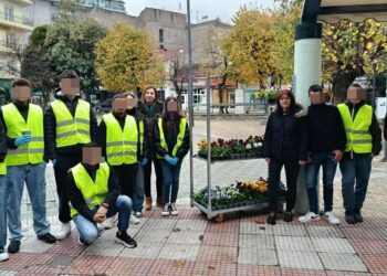 Μια ομάδα μαθητών με γιλέκα υψηλής ορατότητας στέκεται στην κεντρική πλατεία της Φλώρινας, έτοιμοι να ξεκινήσουν τις ανθοφυτεύσεις.