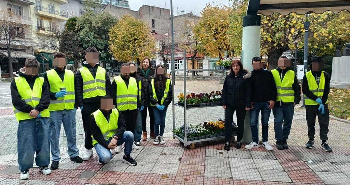 Μια ομάδα μαθητών με γιλέκα υψηλής ορατότητας στέκεται στην κεντρική πλατεία της Φλώρινας, έτοιμοι να ξεκινήσουν τις ανθοφυτεύσεις.