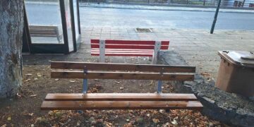 Δύο ξύλινα παγκάκια σε δημόσιο χώρο στο Αμύνταιο, με φθινοπωρινά φύλλα στο έδαφος, αποτελούν μέρος της αναβάθμισης του δημόσιου χώρου.