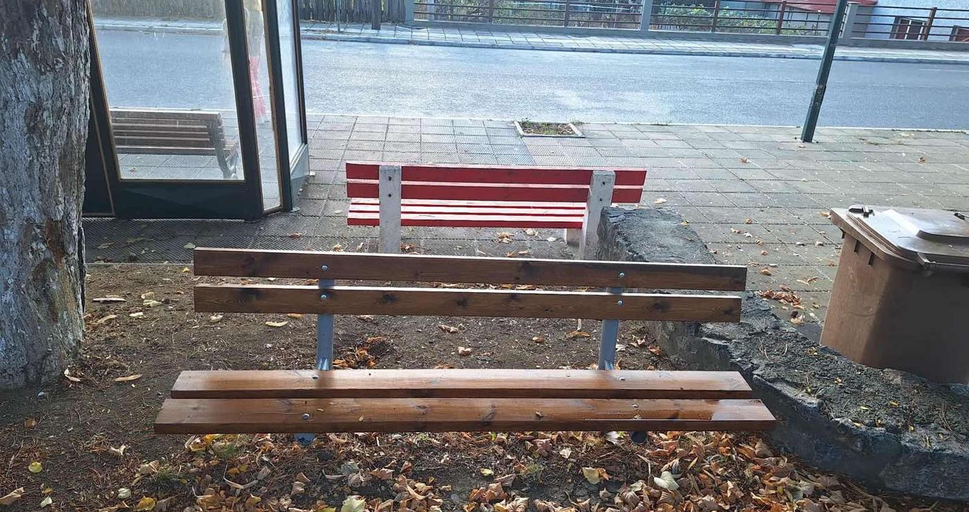 Δύο ξύλινα παγκάκια σε δημόσιο χώρο στο Αμύνταιο, με φθινοπωρινά φύλλα στο έδαφος, αποτελούν μέρος της αναβάθμισης του δημόσιου χώρου.