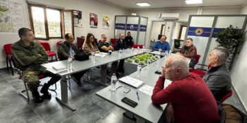 Μια ομάδα ανθρώπων συνεδριάζει σε ένα φωτεινό δωμάτιο στο Δημαρχείο Φλώρινας για να συζητήσουν τις ετοιμασίες για τις επερχόμενες χιονοπτώσεις στη Φλώρινα.