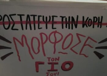 Ένα χειρόγραφο πανό με κόκκινα γράμματα αναγράφει "Προστατεύστε την κόρη σου - Μορφωστε τον γιο σου!" στο θεατρικό εργαστήρι για τη βία κατά των γυναικών.