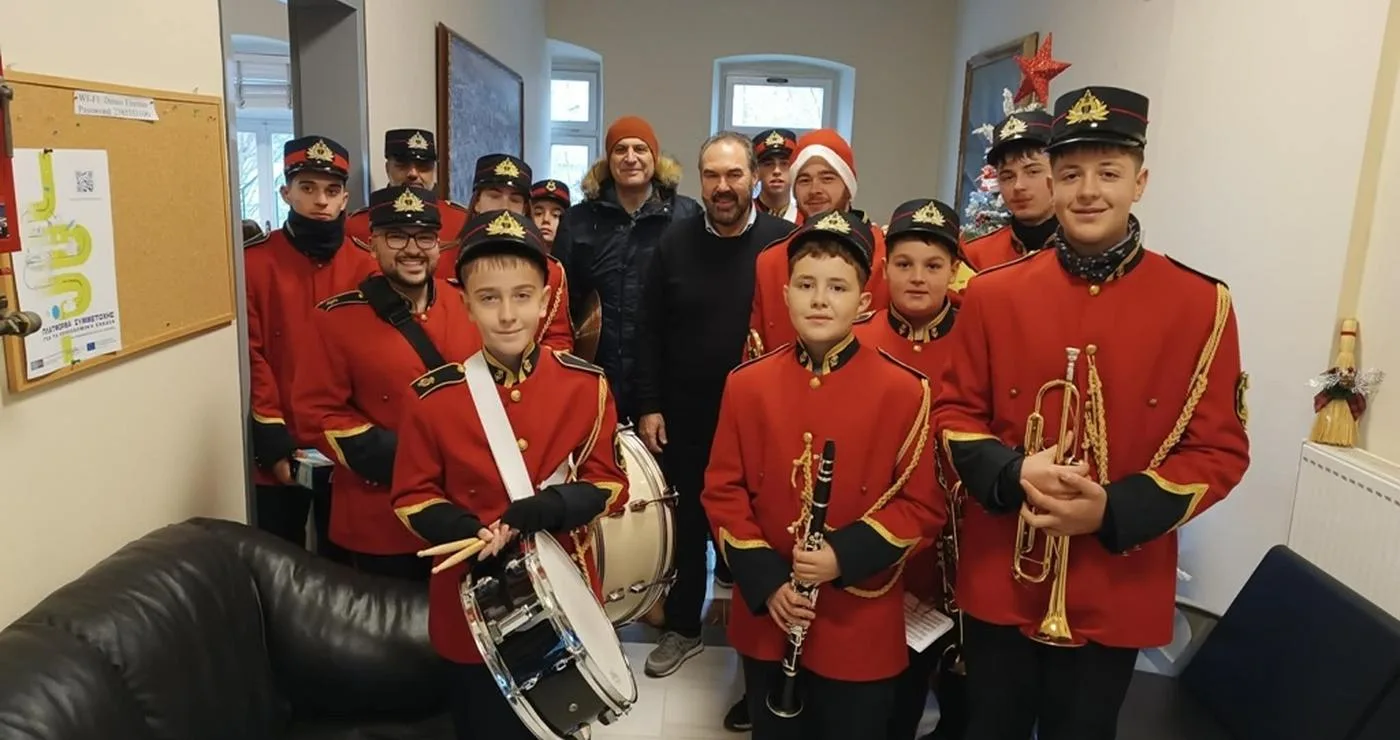 Μια ομάδα μαθητών της φιλαρμονικής του Δήμου Φλώρινας, ντυμένοι με κόκκινα στολή, εψάλλουν χριστουγεννιατικα καλαντα στο Δημαρχείο Φλώρινας.