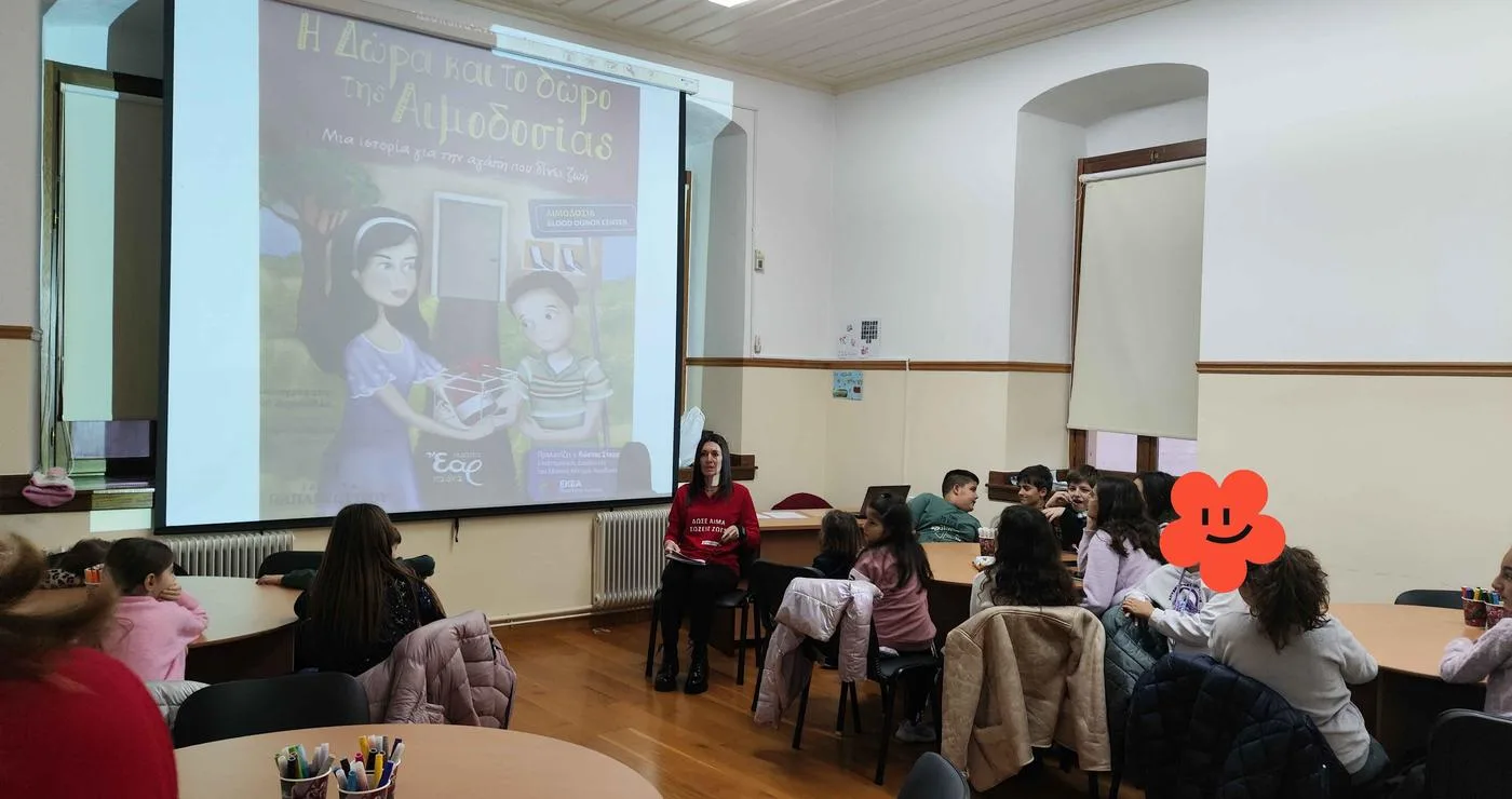 Μια ομάδα παιδιών παρακολουθεί την παρουσίαση του βιβλίου “Η Δώρα και το δώρο της αιμοδοσίας” στην εκδήλωση αιμοδοσία Σιάτιστας στο Τραμπάντζειο Γυμνάσιο.