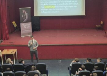 Ο συγγραφέας και Life Coach Χρήστος Τούβε μιλάει στους μαθητές του Γυμνασίου Αμυνταίου για τον σχολικό εκφοβισμό, ενώ μια διαφάνεια προβάλλεται στο φόντο.