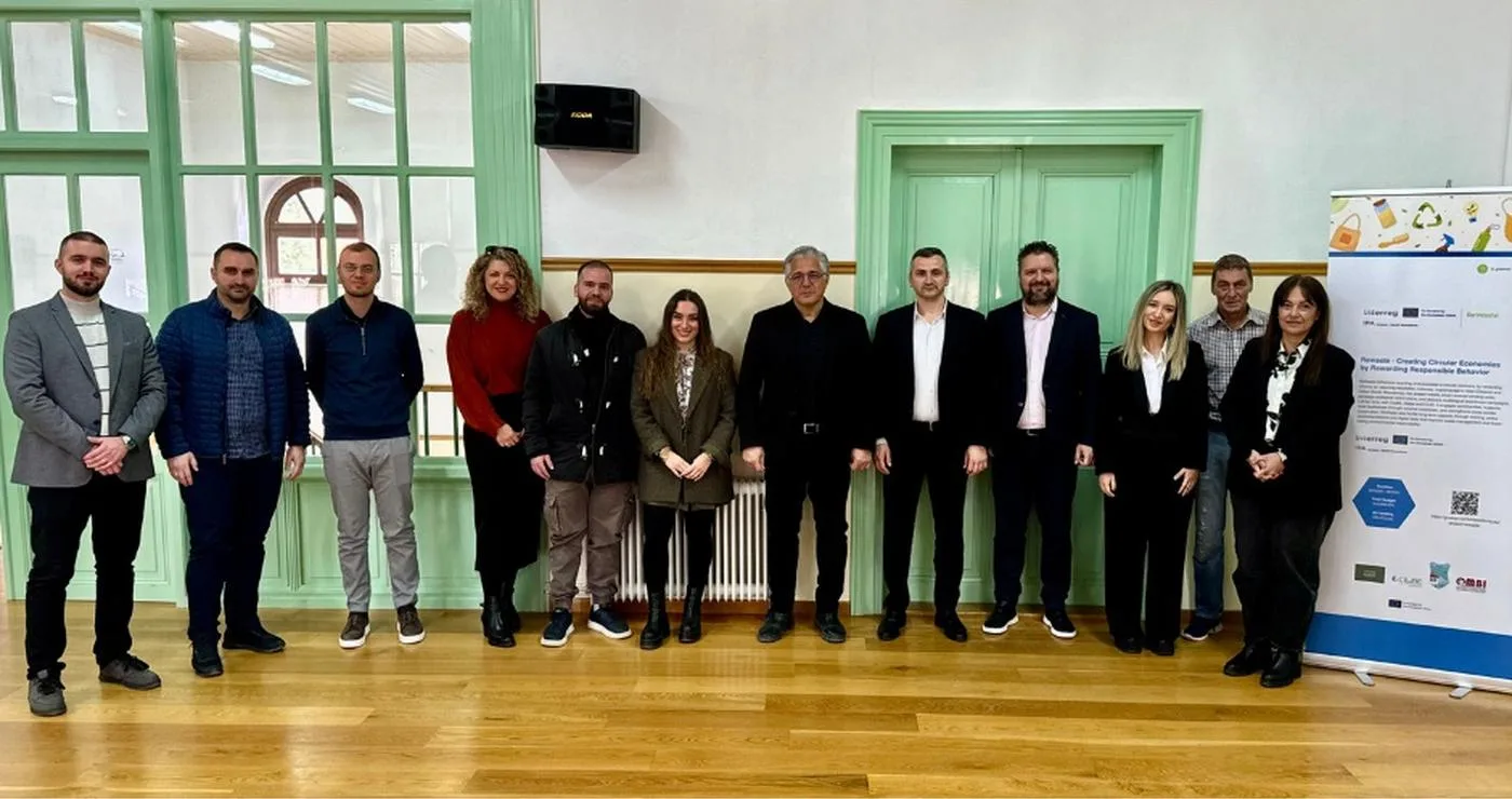 Ομάδα ανθρώπων στέκεται μπροστά από μια σειρά από πράσινες πόρτες στο Τραμπάντζειο Γυμνάσιο στη Σιάτιστα, κατά την εναρκτήρια συνάντηση του έργου Δήμος Βοΐου ReWaste.