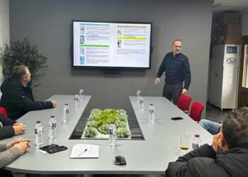 A group of men are seated around a conference table in a meeting room discussing the plan for snow removal in Florina.