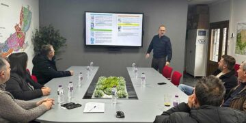 A group of men are seated around a conference table in a meeting room discussing the plan for snow removal in Florina.