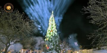 Ένα λαμπερό Χριστουγεννιάτικο δέντρο φωτίζει την Πλατεία Αγοράς στο Αμύνταιο, με πλήθος κόσμου να παρακολουθεί την εορταστική εκδήλωση.