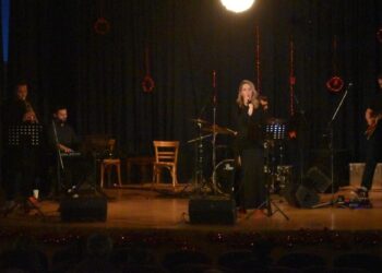 Μια γυναίκα τραγουδάει με μικρόφωνο μπροστά από μια τζαζ μπάντα στην σκηνή, κατά τη διάρκεια των χριστουγεννιάτικων εκδηλώσεων Φλώρινας.