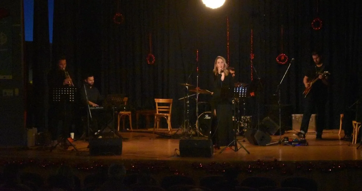 Μια γυναίκα τραγουδάει με μικρόφωνο μπροστά από μια τζαζ μπάντα στην σκηνή, κατά τη διάρκεια των χριστουγεννιάτικων εκδηλώσεων Φλώρινας.