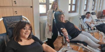 Εθελοντές αιμοδότες χαμογελαστοί κατά τη διάρκεια της αιμοδοσίας στη Σιάτιστα, με ιατρικό προσωπικό να τους επιβλέπει.