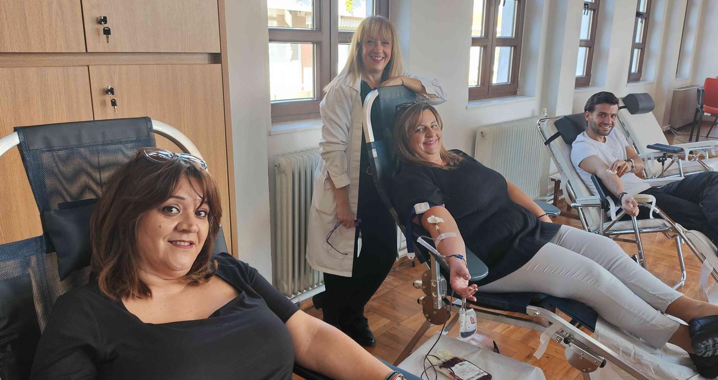 Εθελοντές αιμοδότες χαμογελαστοί κατά τη διάρκεια της αιμοδοσίας στη Σιάτιστα, με ιατρικό προσωπικό να τους επιβλέπει.