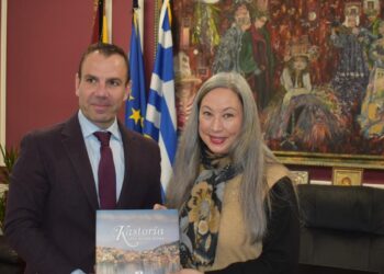 Ο Δήμαρχος Καστοριάς και η Καναδική Πρέσβης χαμογελούν καθώς κρατούν ένα λεύκωμα με θέμα την Καστοριά, υπογραμμίζοντας τη στενή σχέση μεταξύ της πόλης και του Καναδά.