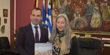 Ο Δήμαρχος Καστοριάς και η Καναδική Πρέσβης χαμογελούν καθώς κρατούν ένα λεύκωμα με θέμα την Καστοριά, υπογραμμίζοντας τη στενή σχέση μεταξύ της πόλης και του Καναδά.