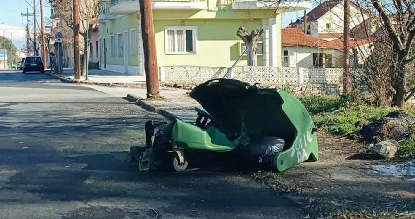 Ένας πράσινος κάδος απορριμμάτων έχει ανατραπεί στον δρόμο στη Φλώρινα, με σκουπίδια να έχουν χυθεί γύρω του, δείχνοντας ένα κοινό πρόβλημα με τα απορριμματα φλωρινα.