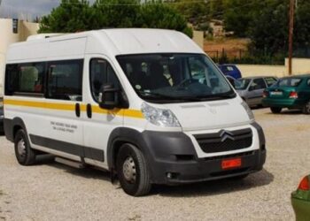 Λευκό βαν του ΕΟΔΥ Αμύνταιο σταθμεύει σε έναν αστικό δρόμο, έτοιμο να προσφέρει πρωτοβάθμια υγειονομική φροντίδα σε απομακρυσμένες κοινότητες.