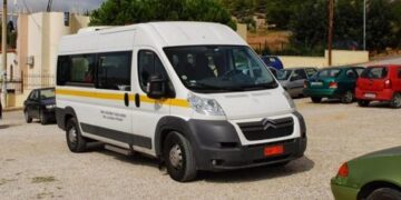 Λευκό βαν του ΕΟΔΥ Αμύνταιο σταθμεύει σε έναν αστικό δρόμο, έτοιμο να προσφέρει πρωτοβάθμια υγειονομική φροντίδα σε απομακρυσμένες κοινότητες.