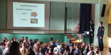 Μαθητές παρακολουθούν ενημερωτική διάλεξη κυκλοφοριακής αγωγής στο Πειραματικό Δημοτικό Σχολείο Φλώρινας, με αστυνομικό να παρουσιάζει τους κανόνες οδικής συμπεριφοράς.