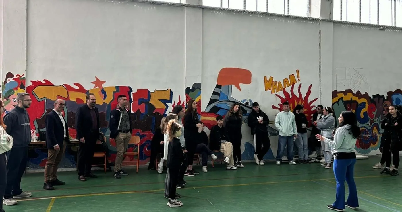 Μια ομάδα πολιτών συμμετέχει σε μαθήματα αυτοάμυνας στο γυμναστήριο του 1ου Λυκείου Φλώρινας, με έναν εκπαιδευτή να τους καθοδηγεί.