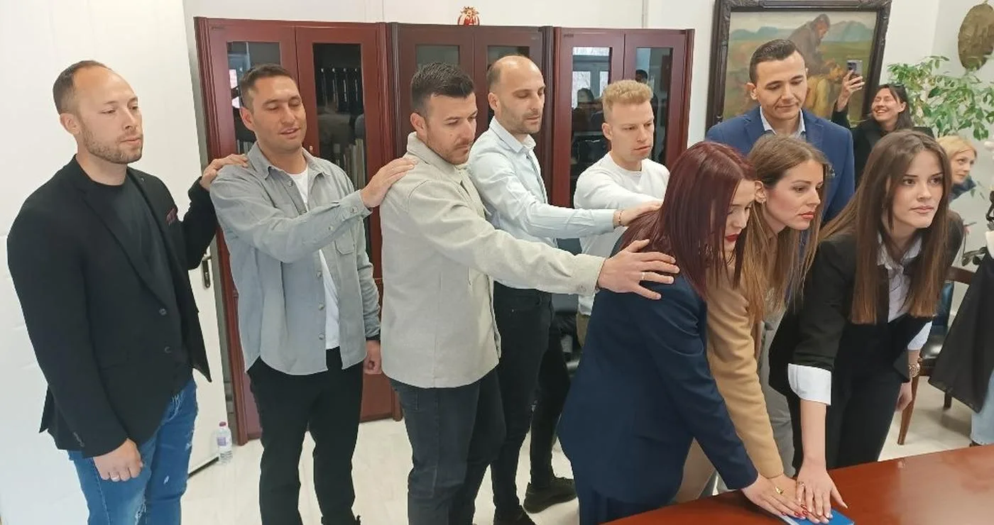 Εννέα νέοι δημοτικοί αστυνομικοί Φλώρινας ορκίζονται με το ένα χέρι υψωμένο, παρουσία συναδέλφων τους σε ένα γραφείο του Δημαρχείου.