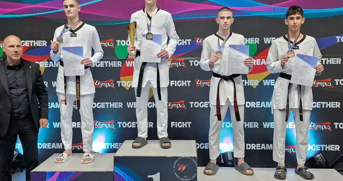 Τέσσερις αθλητές Taekwondo στέκονται στο βάθρο των νικητών στο Πανελλήνιο Πρωτάθλημα, με τον Γιώργο Νιόπλια να κατέχει το χάλκινο μετάλλιο, ως μέρος της Μακεδονικής Δύναμης Κοζάνης.