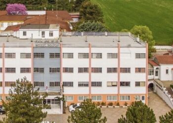 Η πολυώροφη δομή του ΕΠΑΣ Κοζάνης, ο χώρος της εκπαιδευτικής επίσκεψης, φαίνεται σε μια αεροφωτογραφία με γύρω της πράσινη βλάστηση και κτίρια.