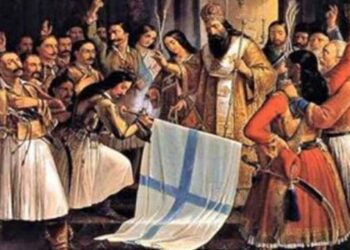 Μια σκηνή από τον εορτασμό της 25ης Μαρτίου 1821, με έναν ιερέα να ευλογεί την ελληνική σημαία ενώ πλήθος ανθρώπων πανηγυρίζει.