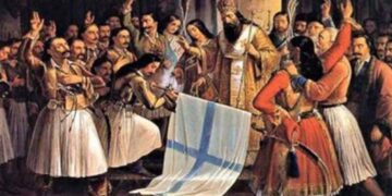 Μια σκηνή από τον εορτασμό της 25ης Μαρτίου 1821, με έναν ιερέα να ευλογεί την ελληνική σημαία ενώ πλήθος ανθρώπων πανηγυρίζει.