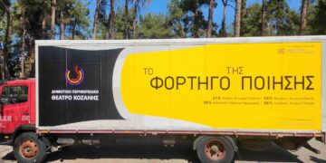 Ένα κόκκινο φορτηγό με την επιγραφή «Το Φορτηγό της Ποίησης» βρίσκεται σε ένα πάρκινγκ με δέντρα, προσφέροντας μια μοναδική θεατρική εμπειρία στην Καστοριά και τα Γρεβενά.