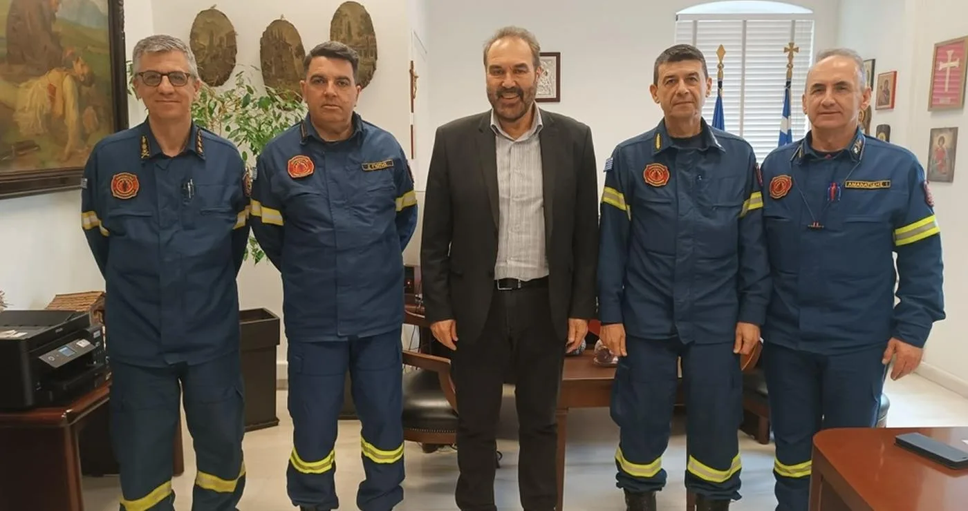 Υψηλόβαθμα στελέχη της Πυροσβεστικής και ο Δήμαρχος Φλώρινας στέκονται για φωτογραφία στο γραφείο του δημάρχου, ενισχύοντας τη συνεργασία του δήμου φλώρινας για την πολιτική προστασία.