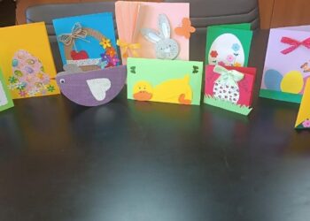 Πασχαλινές κάρτες Φλώρινας με χαρούμενα σχέδια, φτιαγμένες από παιδιά, είναι τοποθετημένες σε ένα τραπέζι.