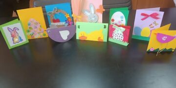 Πασχαλινές κάρτες Φλώρινας με χαρούμενα σχέδια, φτιαγμένες από παιδιά, είναι τοποθετημένες σε ένα τραπέζι.