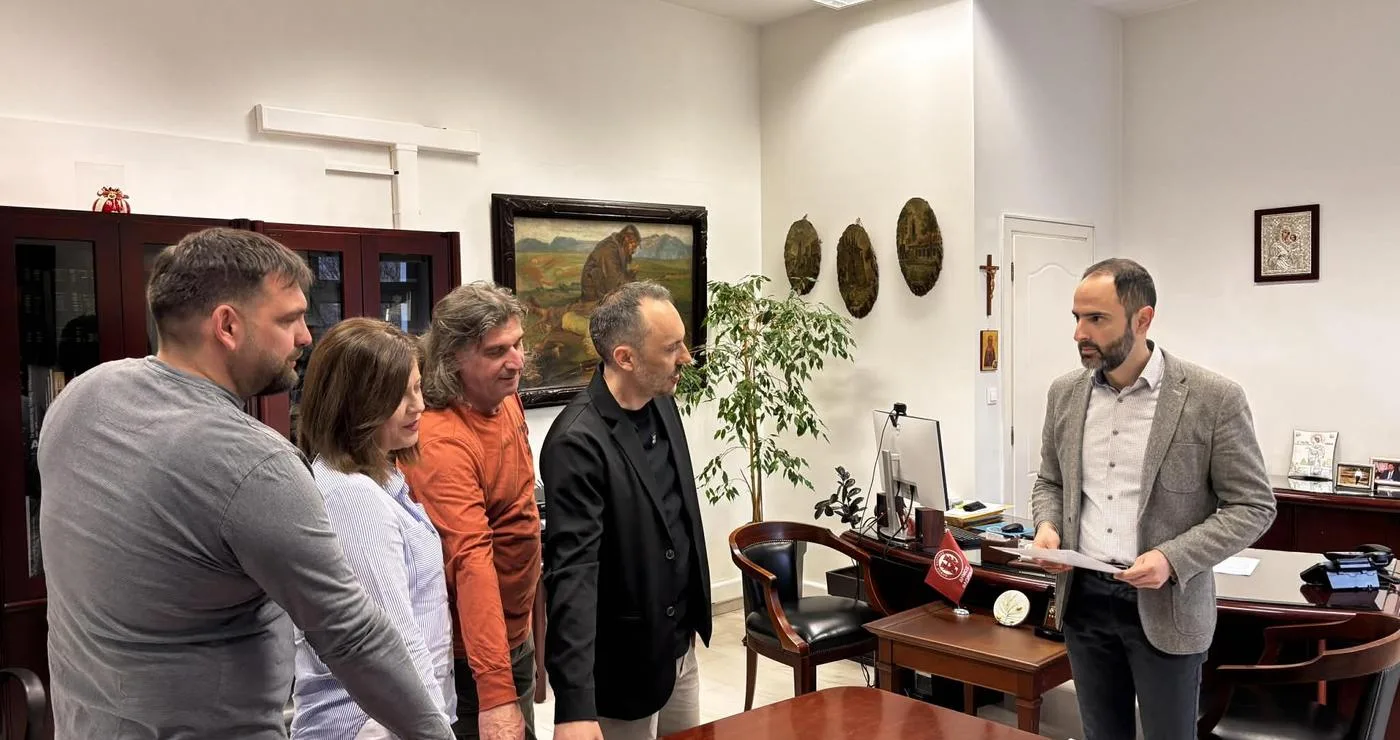 Πέντε νέοι υπάλληλοι του Δήμου Φλώρινας στέκονται γύρω από ένα τραπέζι στο γραφείο του Δημάρχου κατά τη διάρκεια της ορκωμοσίας τους.