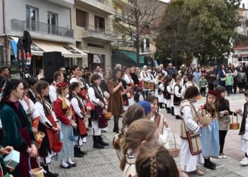 Μια ομάδα χορευτών, ντυμένοι με παραδοσιακά κοστούμια, χορεύουν σε κύκλο στην κεντρική πλατεία της Φλώρινας κατά τη διάρκεια του εθίμου Λάζαρα.