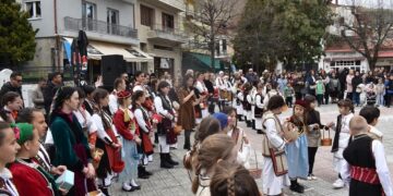 Μια ομάδα χορευτών, ντυμένοι με παραδοσιακά κοστούμια, χορεύουν σε κύκλο στην κεντρική πλατεία της Φλώρινας κατά τη διάρκεια του εθίμου Λάζαρα.