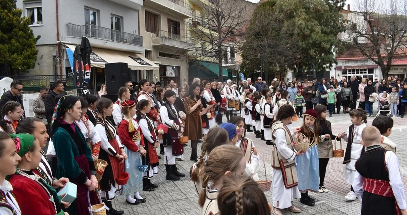 Μια ομάδα χορευτών, ντυμένοι με παραδοσιακά κοστούμια, χορεύουν σε κύκλο στην κεντρική πλατεία της Φλώρινας κατά τη διάρκεια του εθίμου Λάζαρα.
