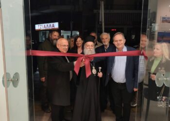 Στην έκθεση φωτογραφίας Γρεβενών, ο Μητροπολίτης Γρεβενών και ο Δήμαρχος κόβουν την κορδέλα στα εγκαίνια, με πλήθος κόσμου να παρακολουθεί.