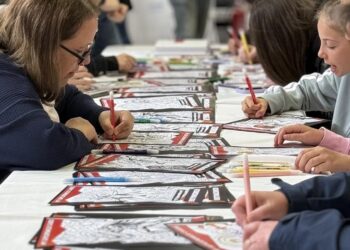 Μαθητές συγκεντρώνονται γύρω από ένα μεγάλο τραπέζι και ζωγραφίζουν σε ένα εργαστήριο για την Ψυχική Υγεία στη Φλώρινα.