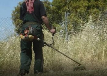 Ένας εργάτης χρησιμοποιεί ένα βενζινοκίνητο χορτοκοπτικό για τον καθαρισμό ενός οικοπέδου στη Φλώρινα, προετοιμάζοντας το για την αντιπυρική περίοδο 2026.